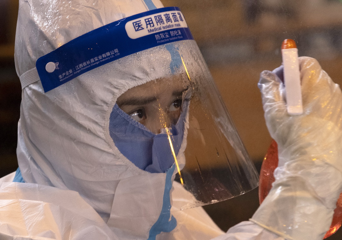 12月2日，在哈尔滨市香坊区安乐街道理工大学核酸检测点，医务人员在进行消毒。