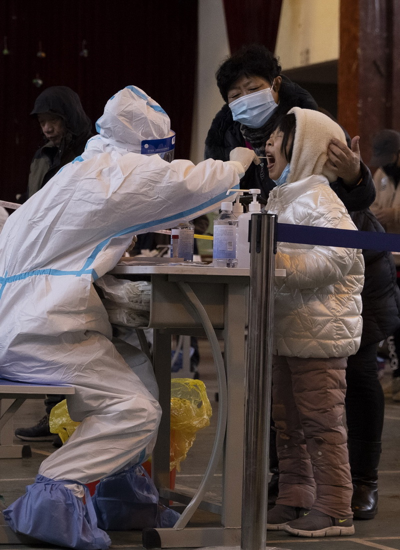 12月2日，在哈爾濱市香坊區安樂街道理工大學核酸檢測點，醫務人員進行核酸採樣。