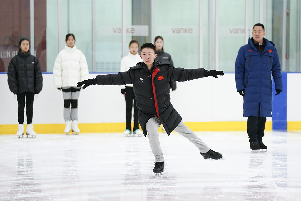 楊曦（前）在張昊（右一）的冰上訓練課上為同學示范花樣滑冰動作（11月19日攝）。新華社記者 鞠煥宗 攝