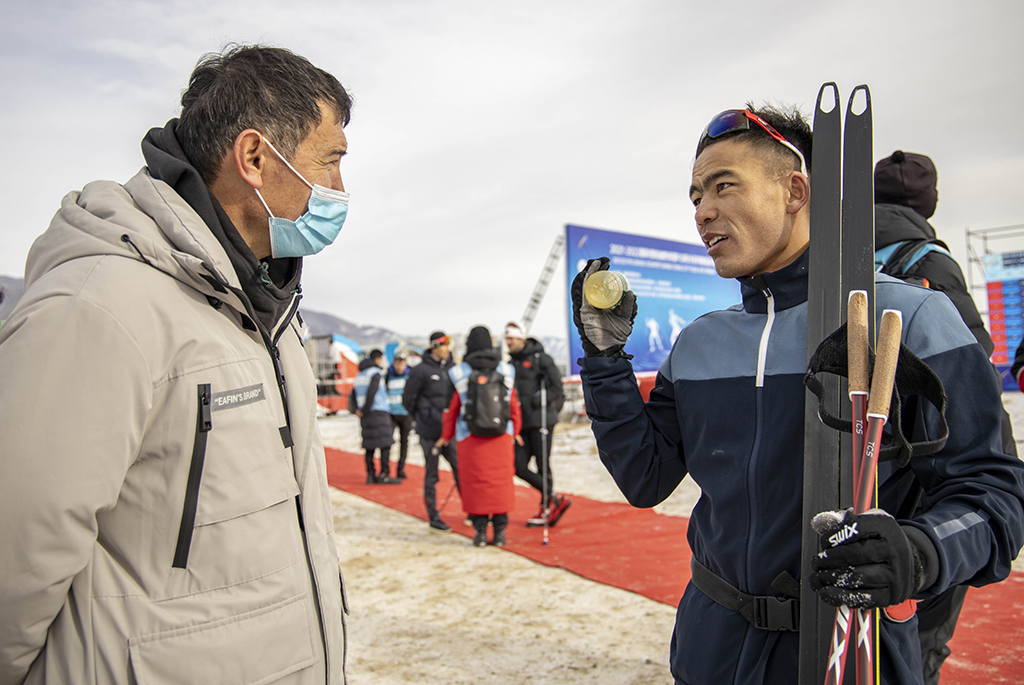 這是一次訓練結束后，在溫泉縣越野滑雪，吐爾鬆江·布爾力克（右）和體育啟蒙老師阿布都沙拉木·賽買提交流（2021年11月22日攝）。這次回鄉訓練比賽，吐爾鬆江吸引了家鄉父老的目光。