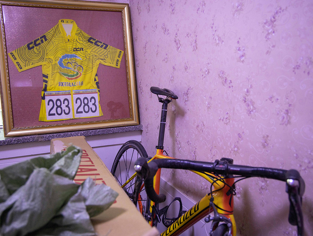 這是吐爾鬆江·布爾力克家中臥室裡擺放的自行車和2018年第十二屆環賽裡木湖公路自行車賽的黃色領騎衫，那是他第一次奪得這項在家鄉舉辦的自行車賽個人總冠軍。（2021年11月25日攝）。
