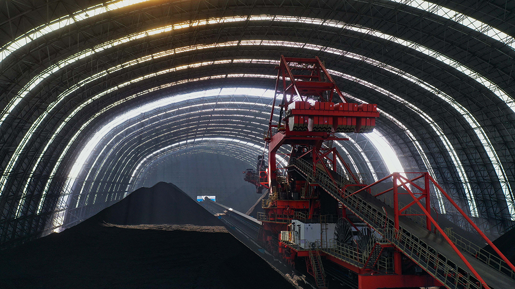 12月7日，唐山港曹妃甸港區煤炭碼頭的一台堆料機在煤倉內工作（無人機照片）。