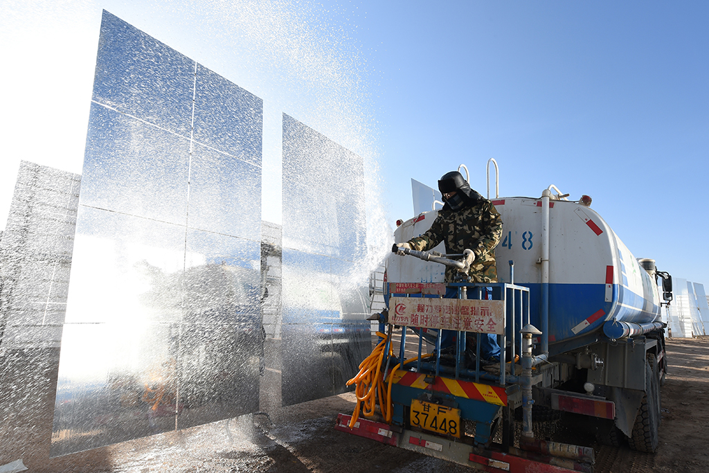 在甘肅玉門鑫能50兆瓦熔鹽塔式光熱電站，工作人員清洗定日鏡（12月8日攝）。
