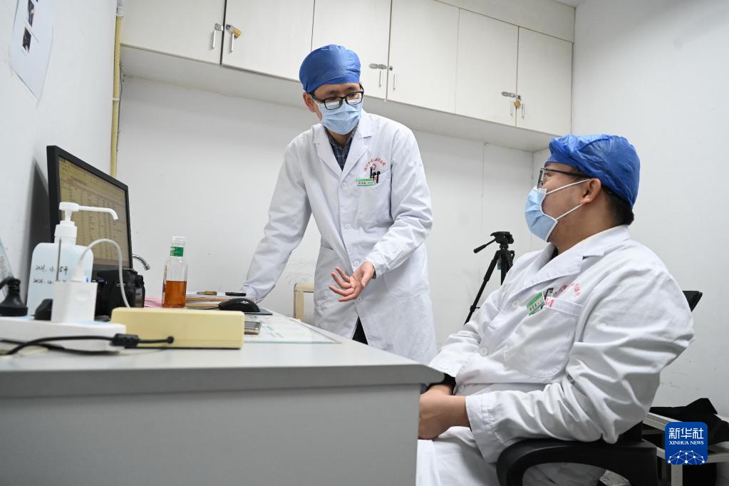 12月8日，陳柏叡（左）和他介紹入院工作的台籍醫生郭宏恩進行皮膚科疑難疾病的專業交流。