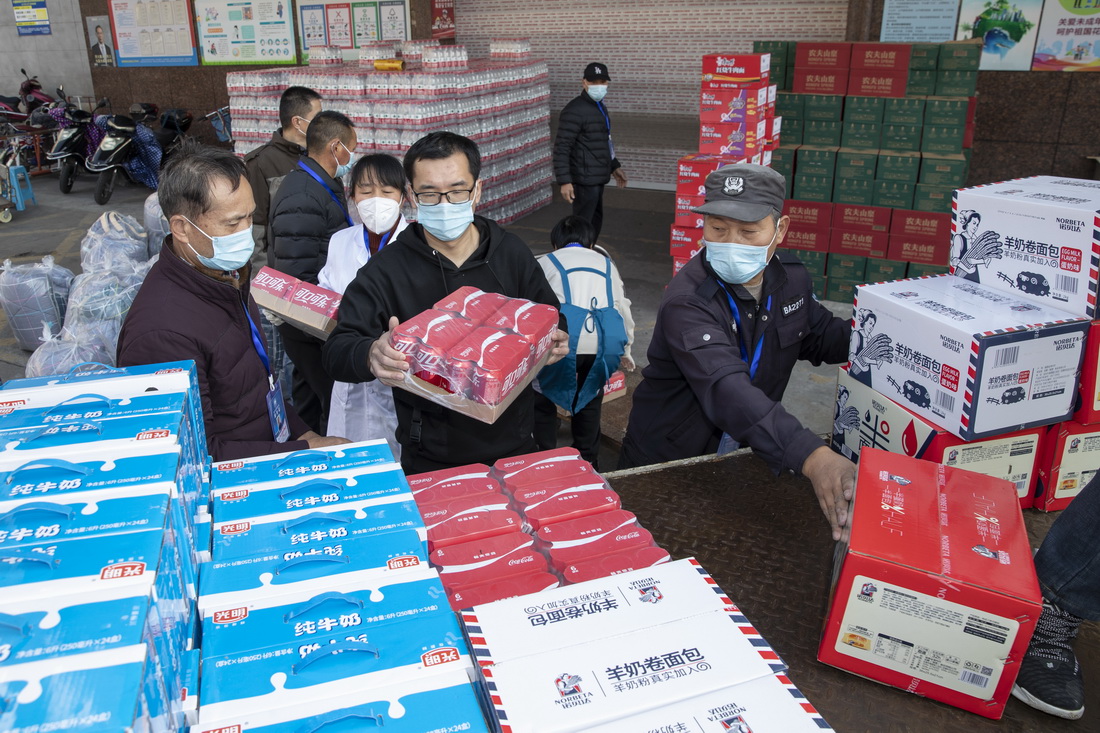 12月13日，浙江省绍兴市上虞区供销系统工作人员将牛奶、面包、饮料等装车，准备送至抗疫一线及居民集中隔离点。新华社发（朱胜钧 摄）