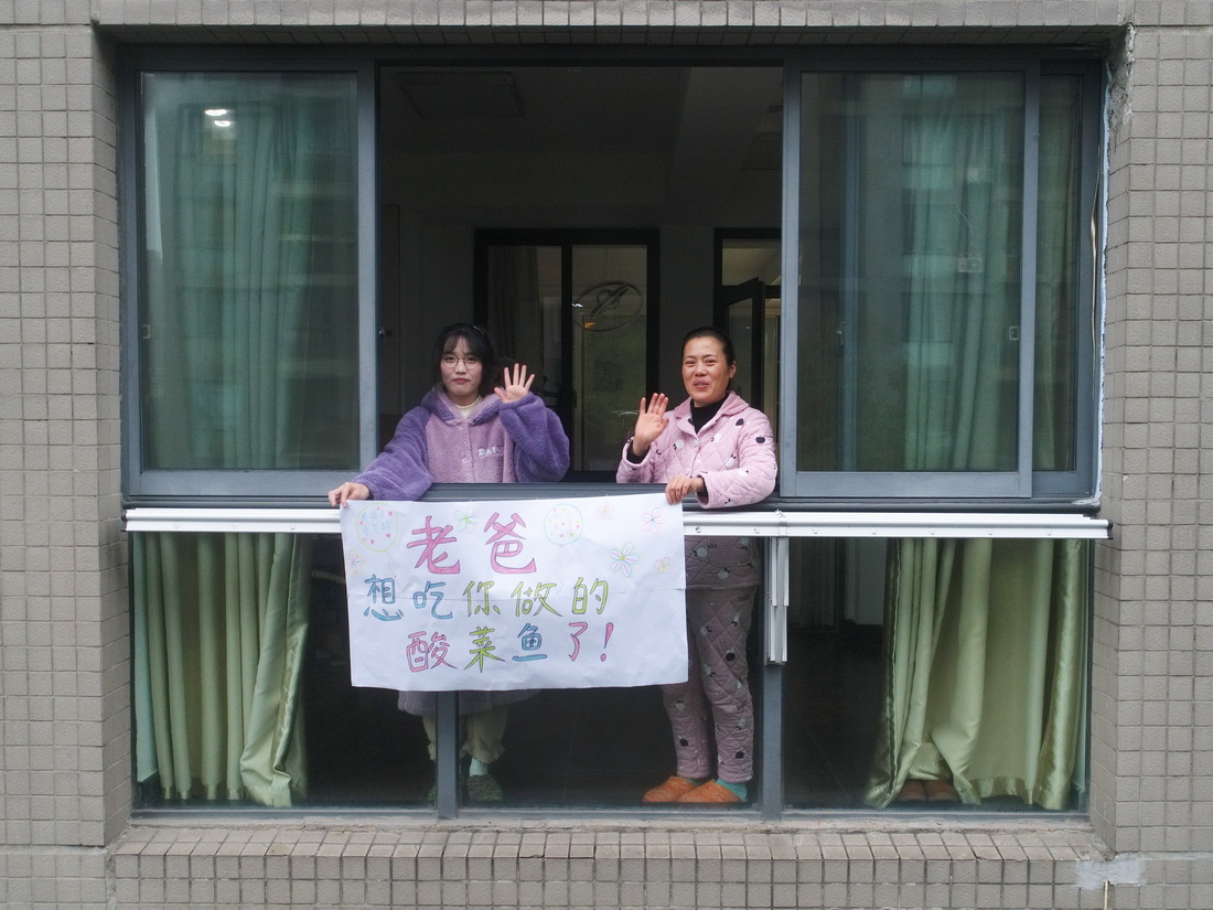 12月16日，英語翻譯嚴小姐（左）和母親嚴女士在家中向因為去老家探親而跟他們分開的父親/丈夫表達想念（無人機照片）。