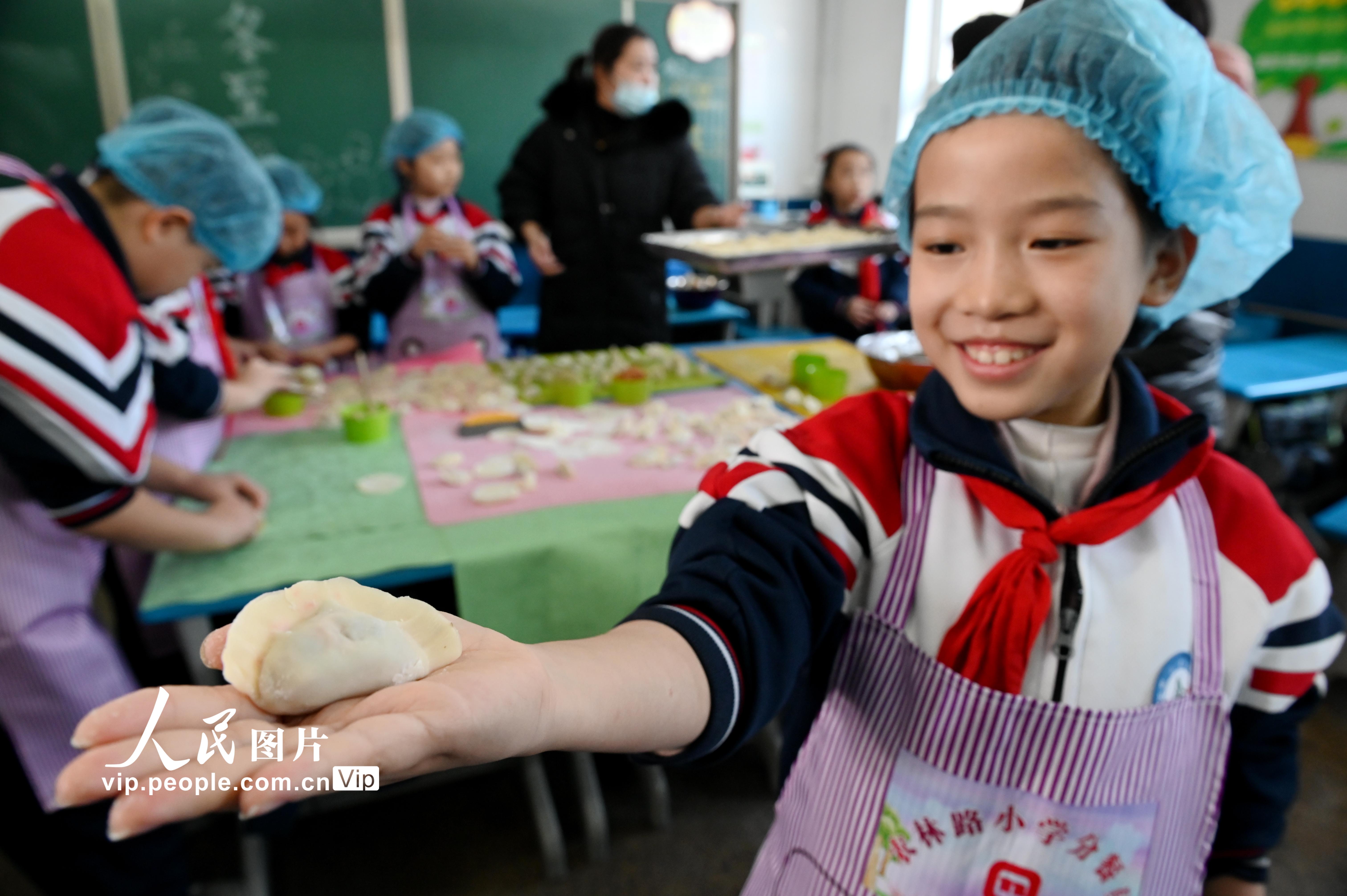 2021年12月20日，河北省邯鄲市邯山區農林路小學的小學生在展示手中包好的餃子。