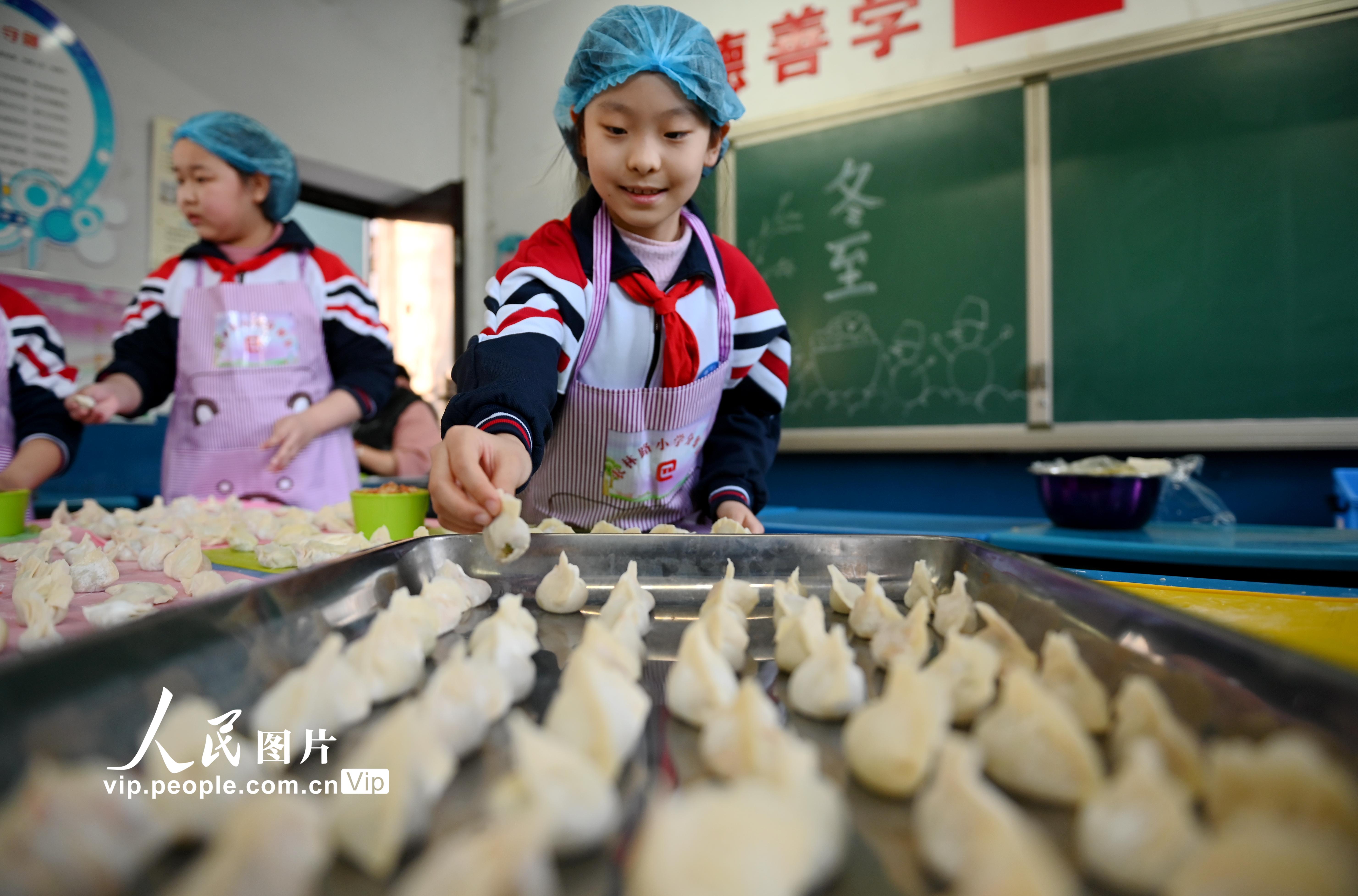 2021年12月20日，河北省邯鄲市邯山區農林路小學的小學生在擺放餃子。