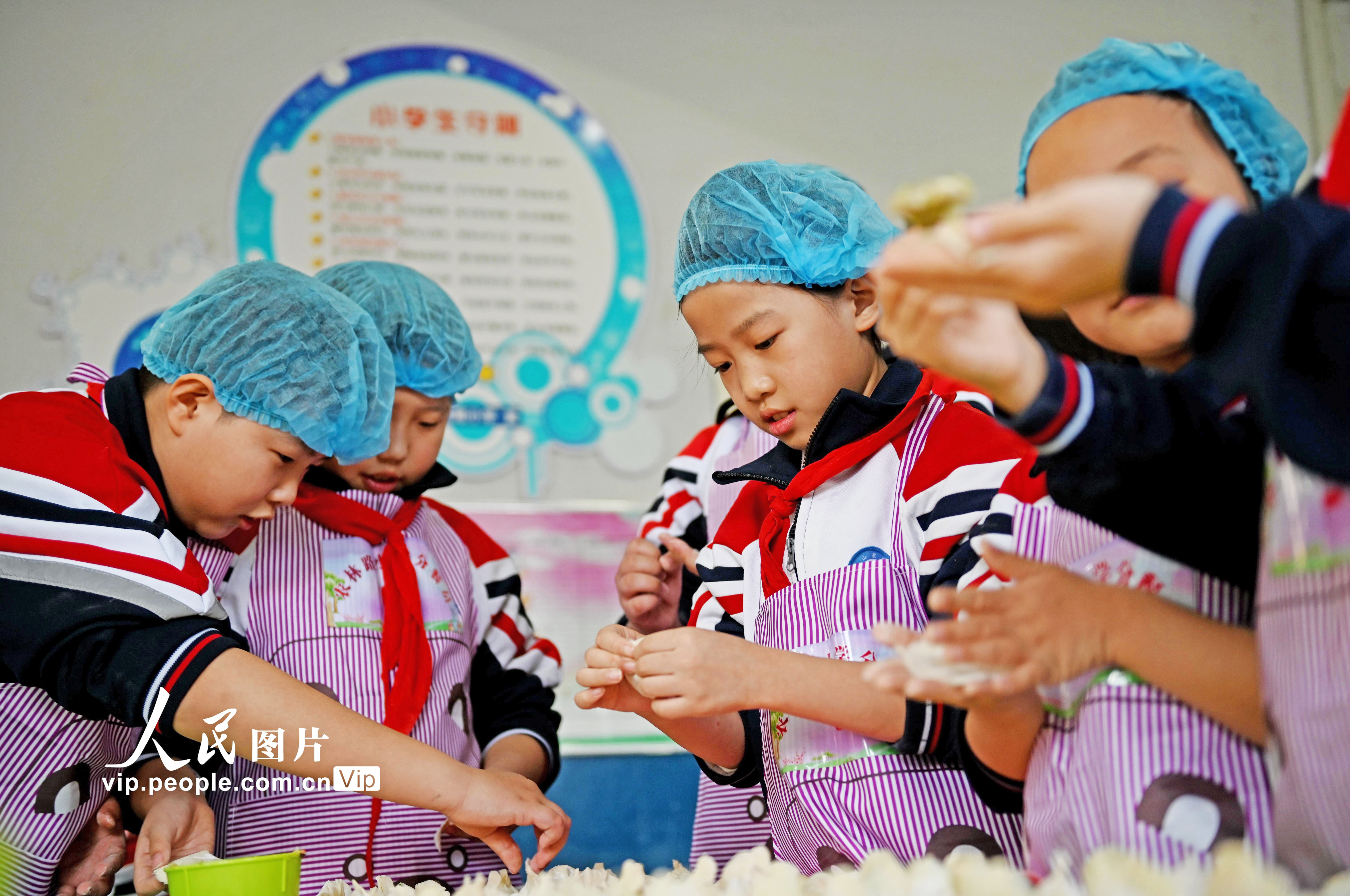 2021年12月20日，河北省邯鄲市邯山區農林路小學的小學生們在包餃子。