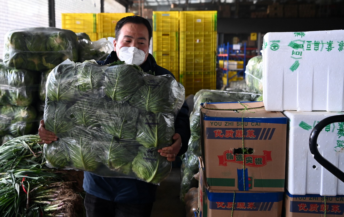 陝西米禾供應鏈管理股份有限公司的工作人員在搬運蔬菜（12月19日攝）。