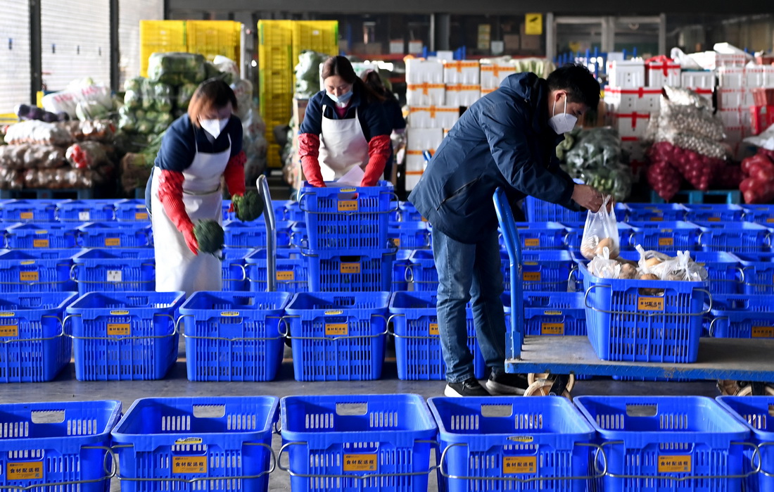 陝西米禾供應鏈管理股份有限公司的工作人員在分裝即將配送的蔬菜（12月19日攝）。