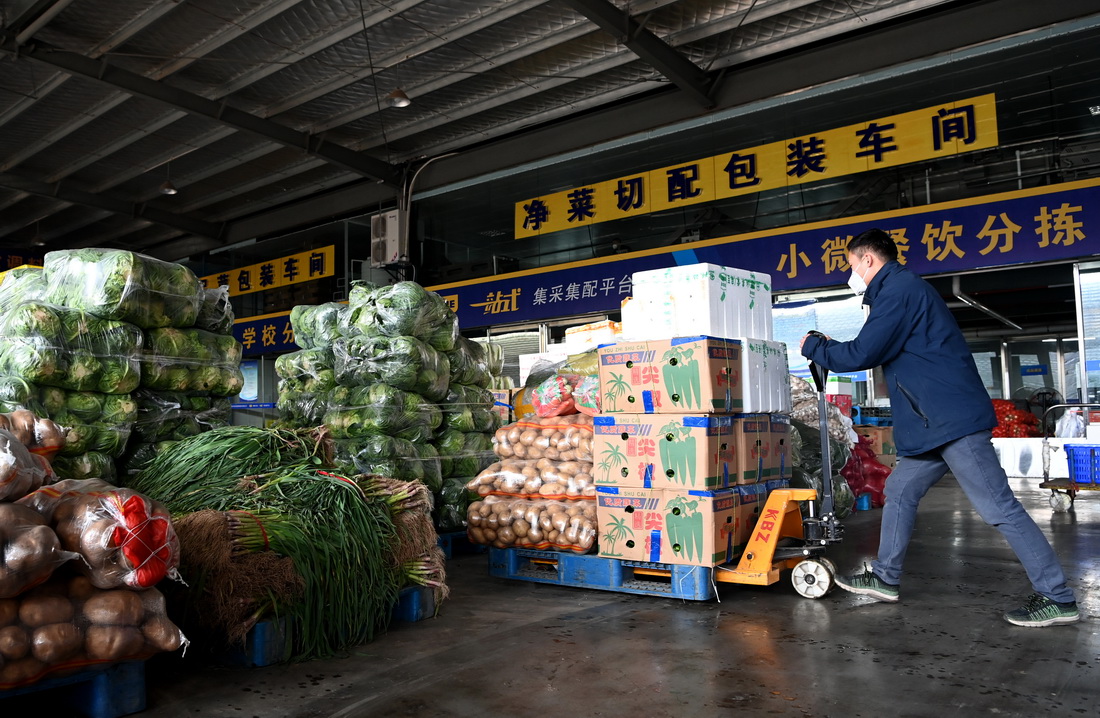 陝西米禾供應鏈管理股份有限公司的工作人員在搬運蔬菜（12月19日攝）。