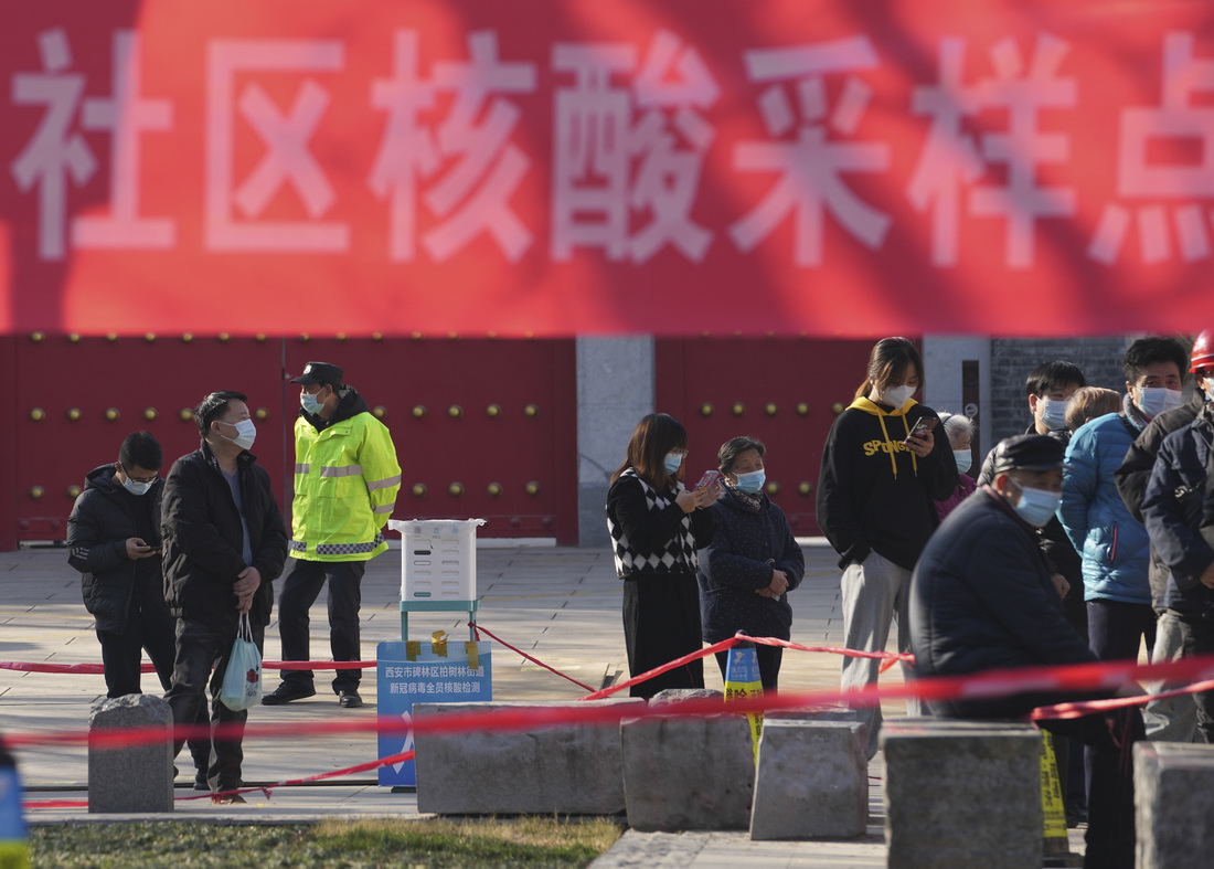 12月21日，居民在西安市開通巷社區核酸採樣點排隊接受核酸檢測。新華社記者 李一博 攝