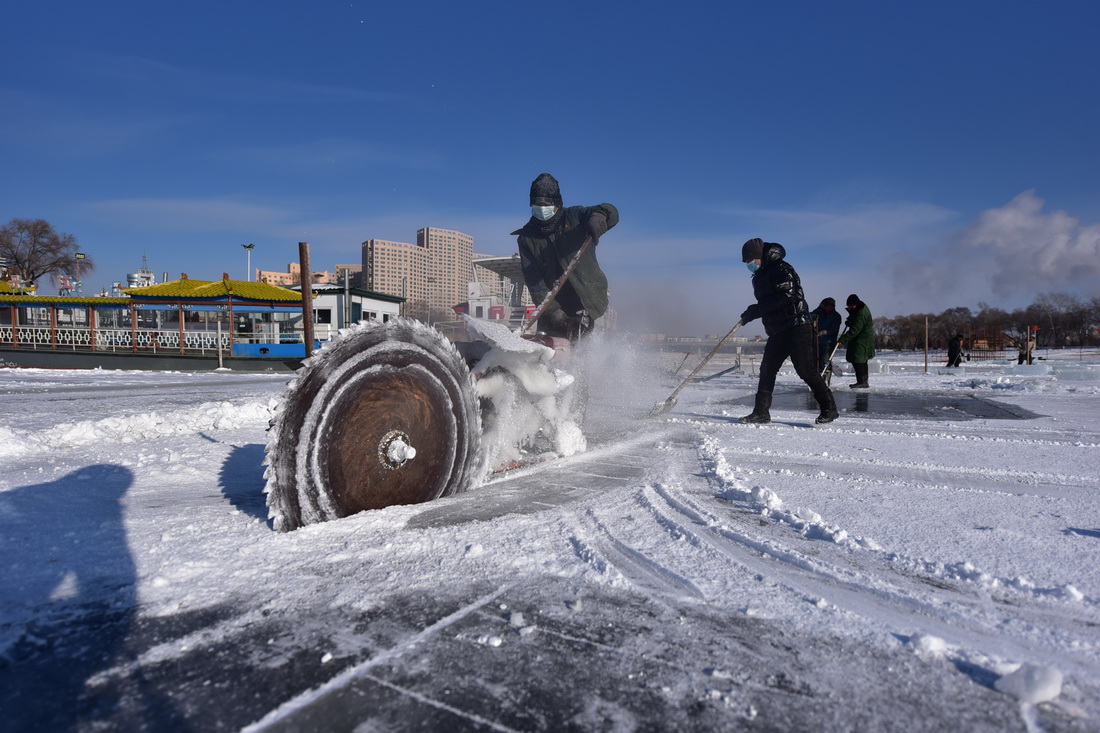 12月26日，在黑龍江省牡丹江市江濱碼頭附近，工人在切割冰塊。