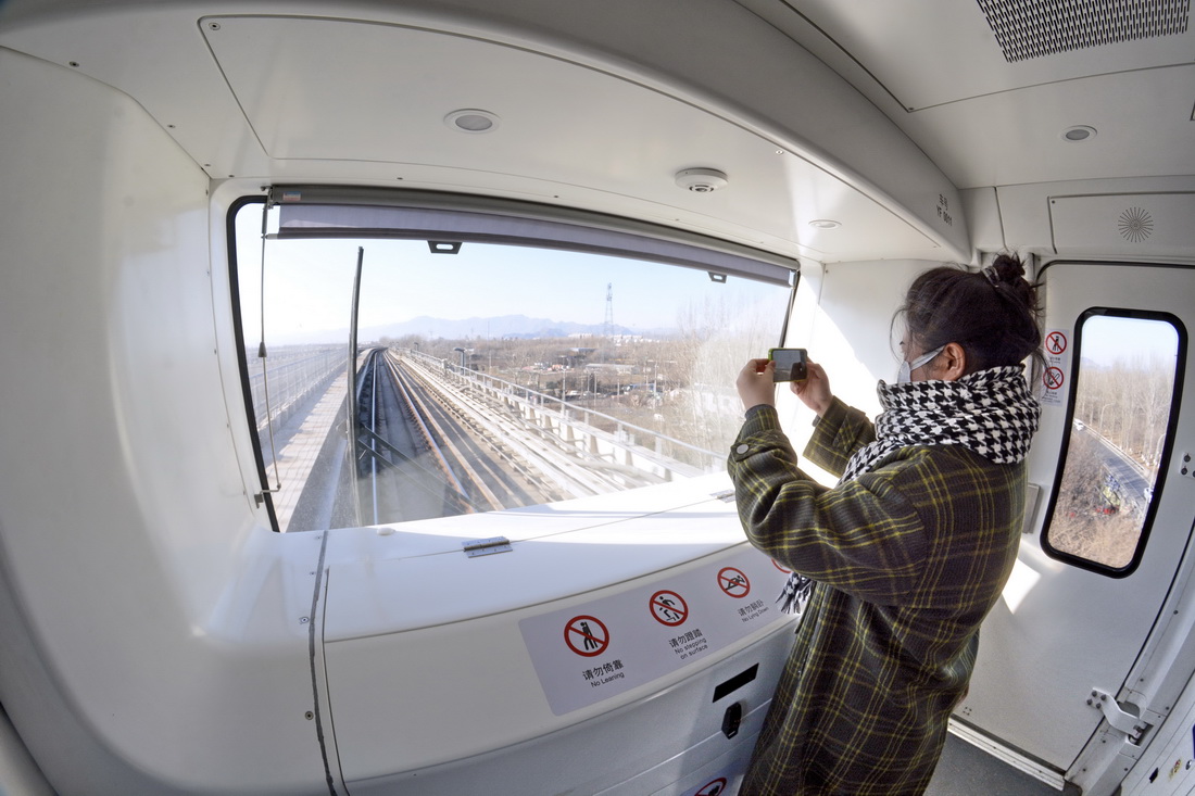 12月26日，乘客在北京地鐵燕房線無人駕駛地鐵列車內拍照。
