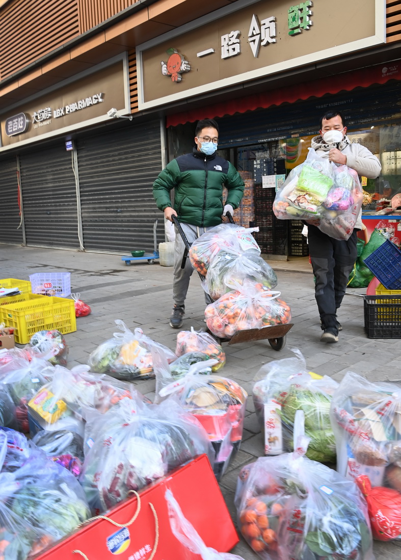 12月29日，西安市碑林區一家生活超市的員工在為市民打包配送蔬菜。
