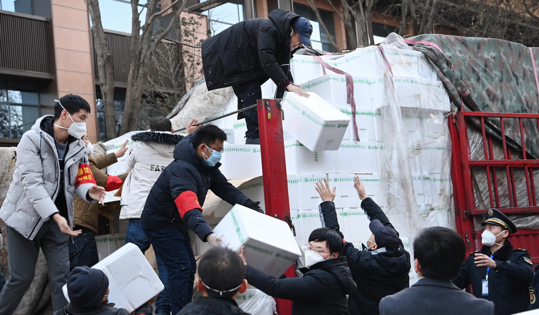 12月29日，西安市新城區西一路街道辦事處人員在搬運配送居民的免費生活物資。