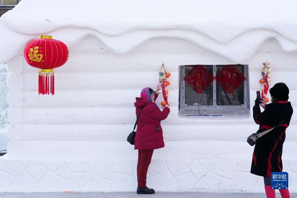 1月1日，在哈爾濱防洪紀念塔廣場，人們在雪屋前拍照。新華社記者 王建威 攝