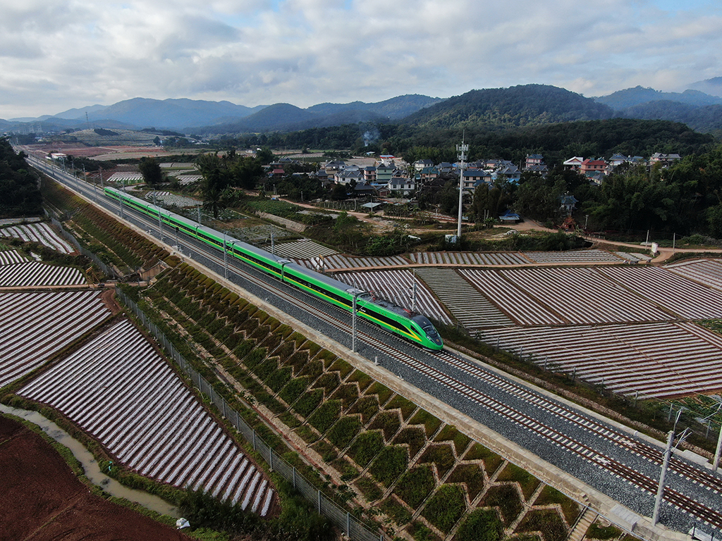 1月3日，列車行駛在位於雲南西雙版納傣族自治州景洪市境內的中老鐵路上（無人機照片）。新華社發（李雲生攝）