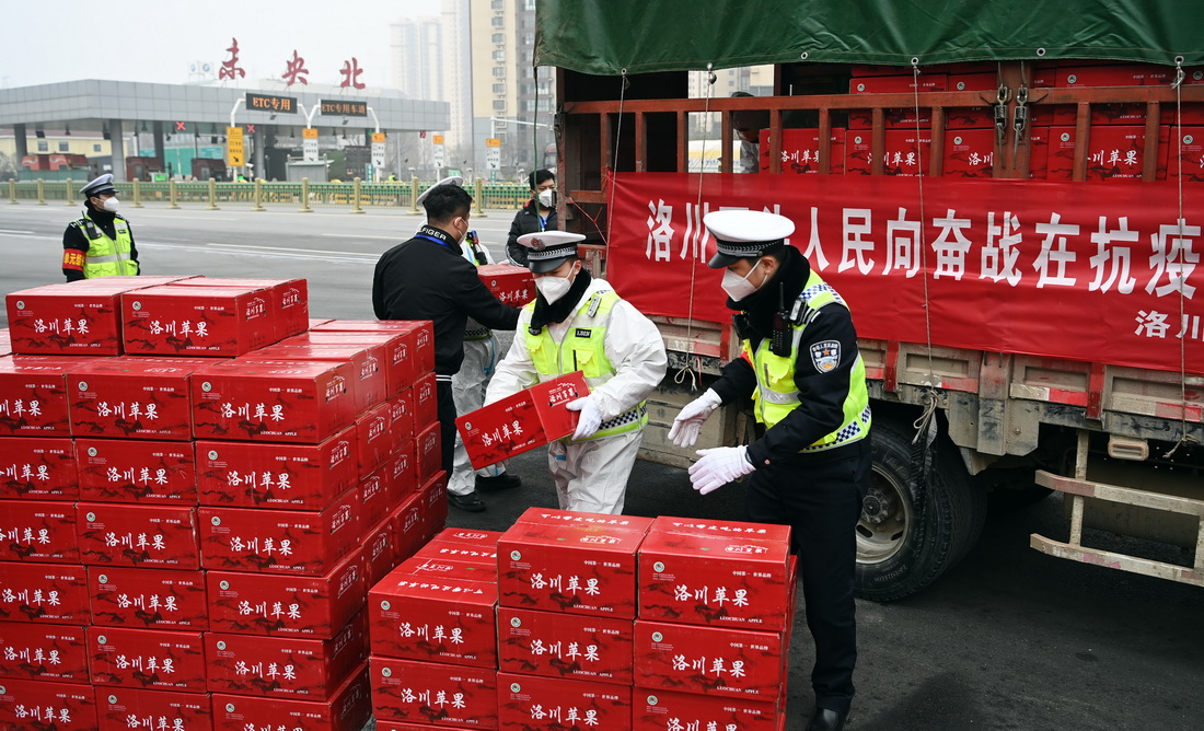 1月6日，西安市志愿者在高速未央北站出口搬运来自延安市洛川县的慰问品。