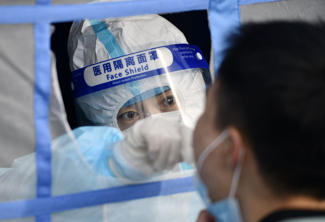 1月9日，在天津濱海高新區的一處核酸檢測點，工作人員在為群眾做核酸採樣。新華社記者 趙子碩 攝