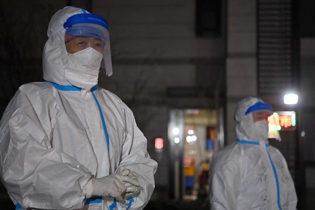 1月9日晚，在天津市西青區中北鎮錦曦花苑社區一核酸檢測點，醫務人員利用工作空隙起身活動。新華社記者 李然 攝