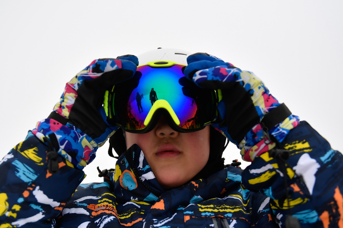 1月9日，在安吉縣雲上草原滑雪場，山川小學的一名學生在滑雪訓練前整理護目鏡。
