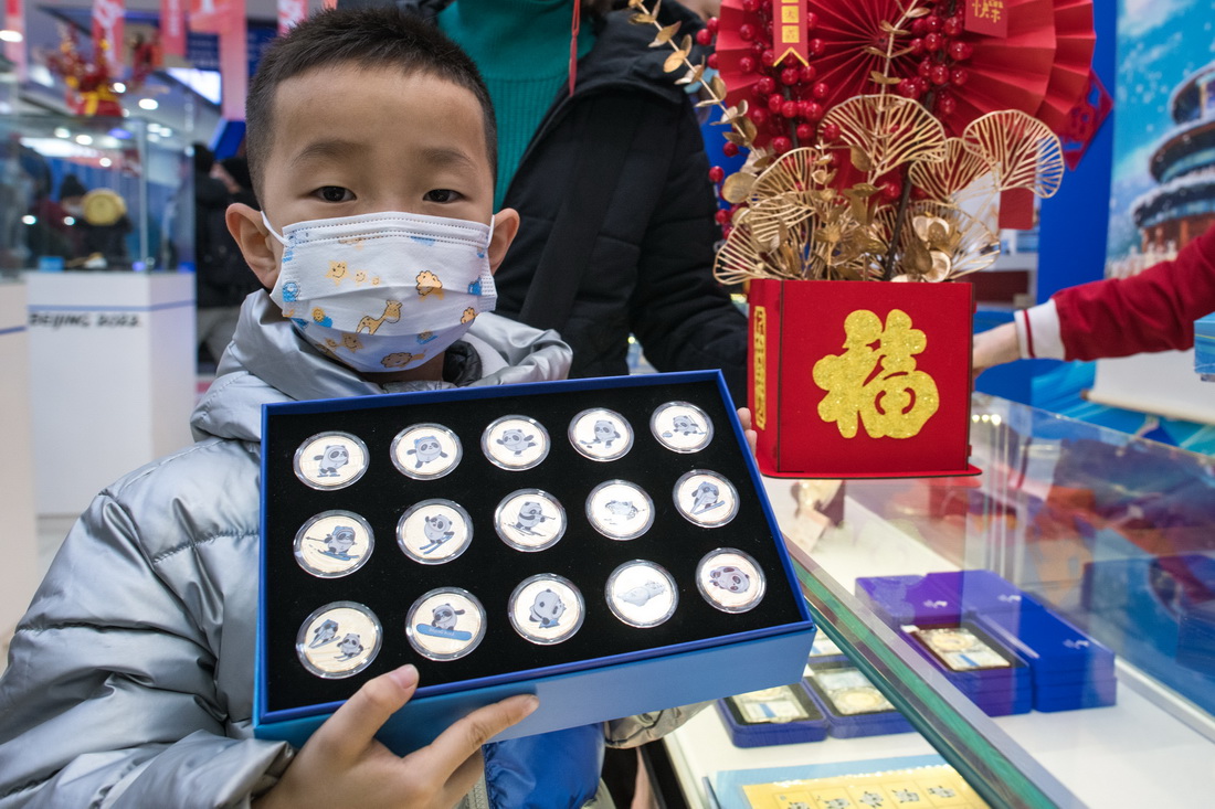 1月12日，一名小朋友展示購買的冬奧紀念品。