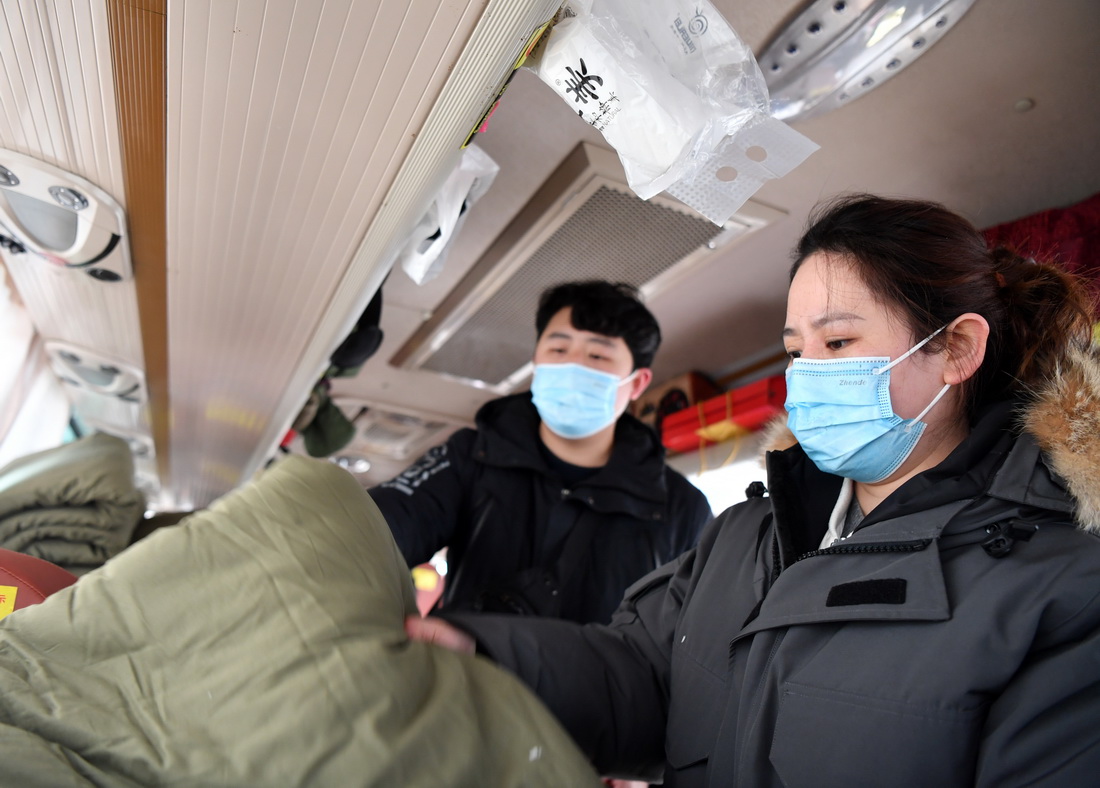 1月11日，在结束当日工作后，张文文（右）与许沛回到大巴车上整理物品。