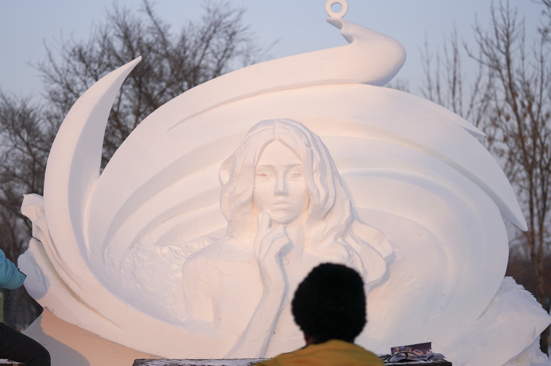1月12日，在哈尔滨太阳岛雪博会园区的雪雕比赛现场，雪雕师在创作中。