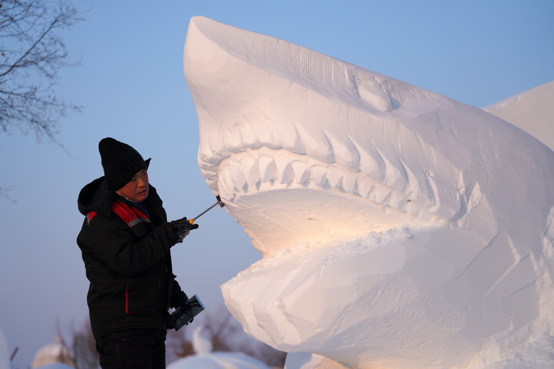 1月12日，在哈尔滨太阳岛雪博会园区的雪雕比赛现场，雪雕师在创作中。