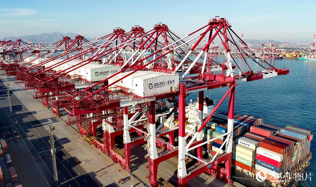 1月14日，在山東港口青島港前灣集裝箱碼頭，一艘貨輪在裝載貨物。