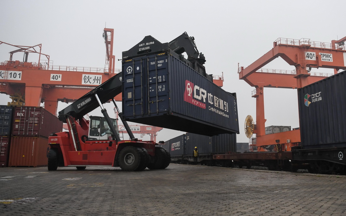 1月15日，在广西钦州港东站，一辆吊车在装运集装箱。