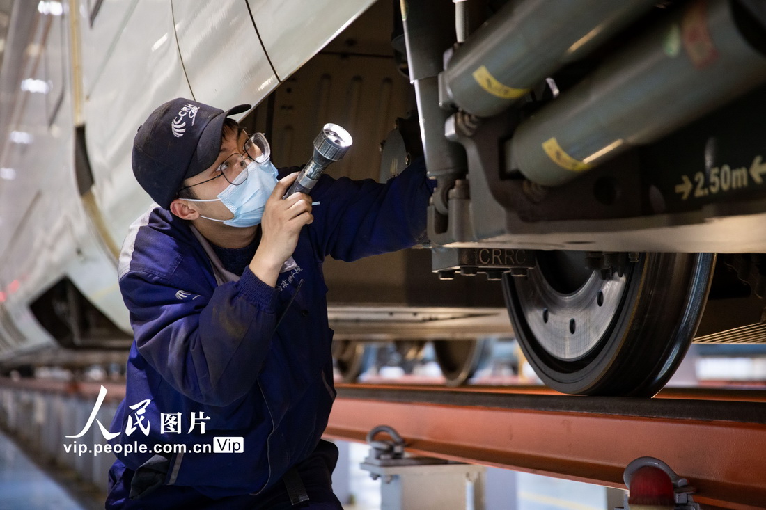 南京動車段南京南動車運用所的地勤機械師在對動車組列車進行檢查維護。