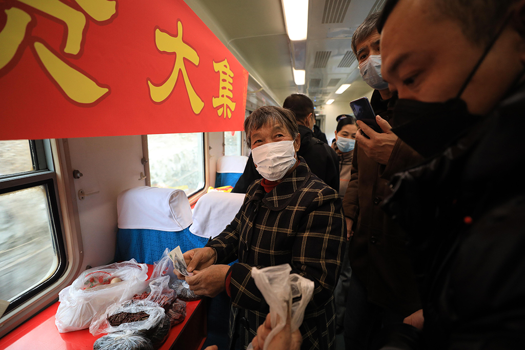 1月15日，在4318次列车上，旅客购买各种山货。新华社记者 杨青 摄
