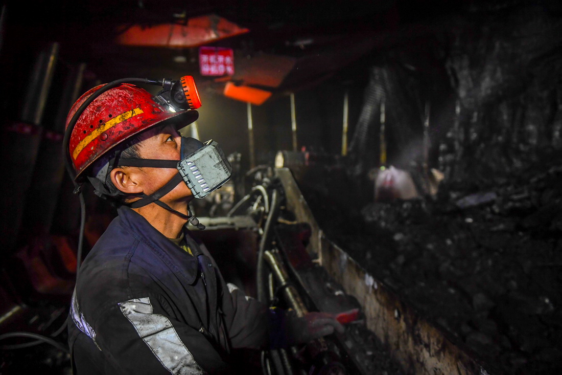 在位于鄂尔多斯市准格尔旗境内的内蒙古伊泰煤炭股份有限公司酸刺沟煤矿矿井下，工人在观察采煤机的作业情况（2021年12月28日摄）。新华社记者 彭源 摄