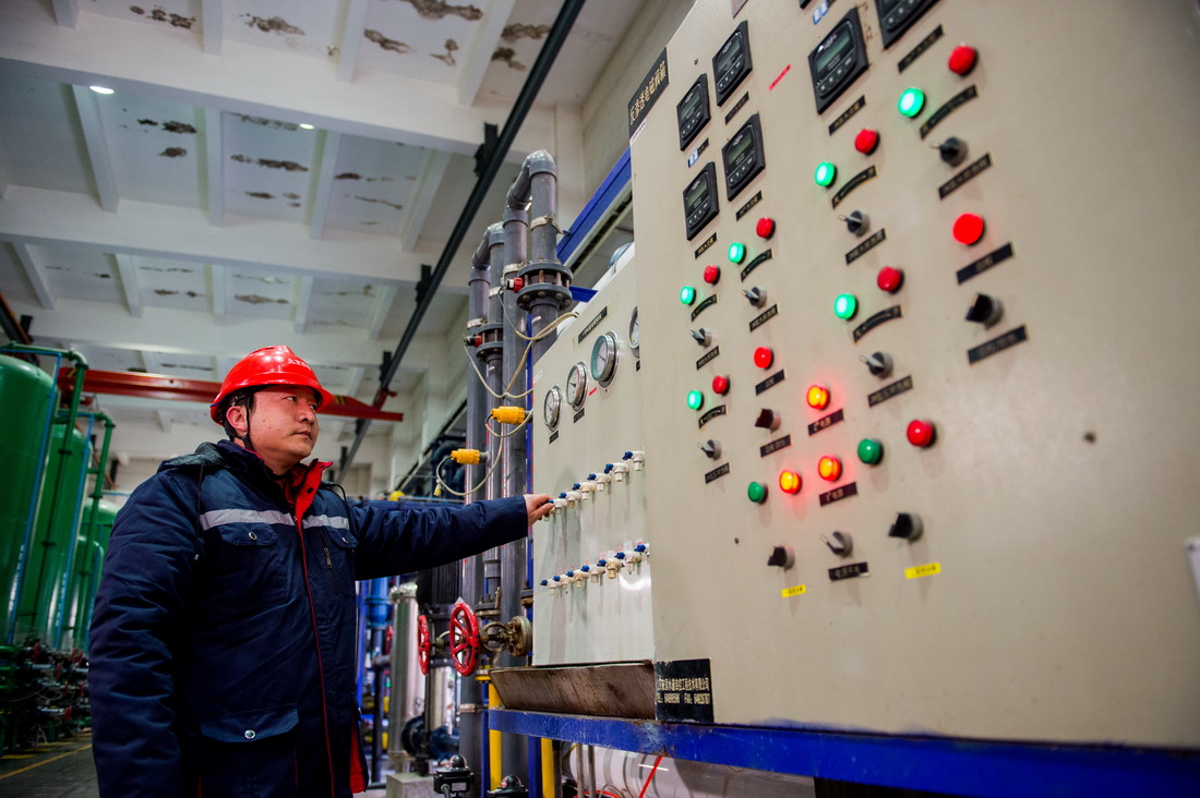 在包头市土默特右旗神华神东电力萨拉齐电厂，员工张军凯在操作热力设备（2021年12月22日摄）。新华社记者 连振 摄