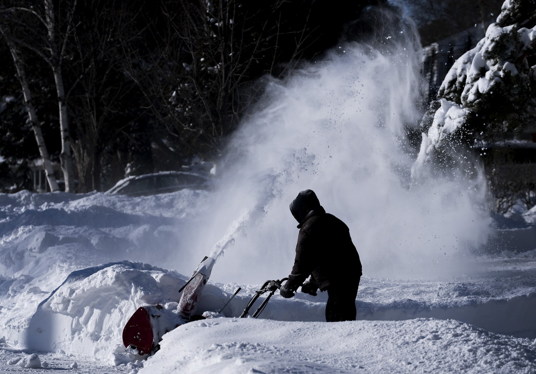 1月18日，在加拿大大多伦多地区米西索加，一名男子清除车道积雪。新华社/美联