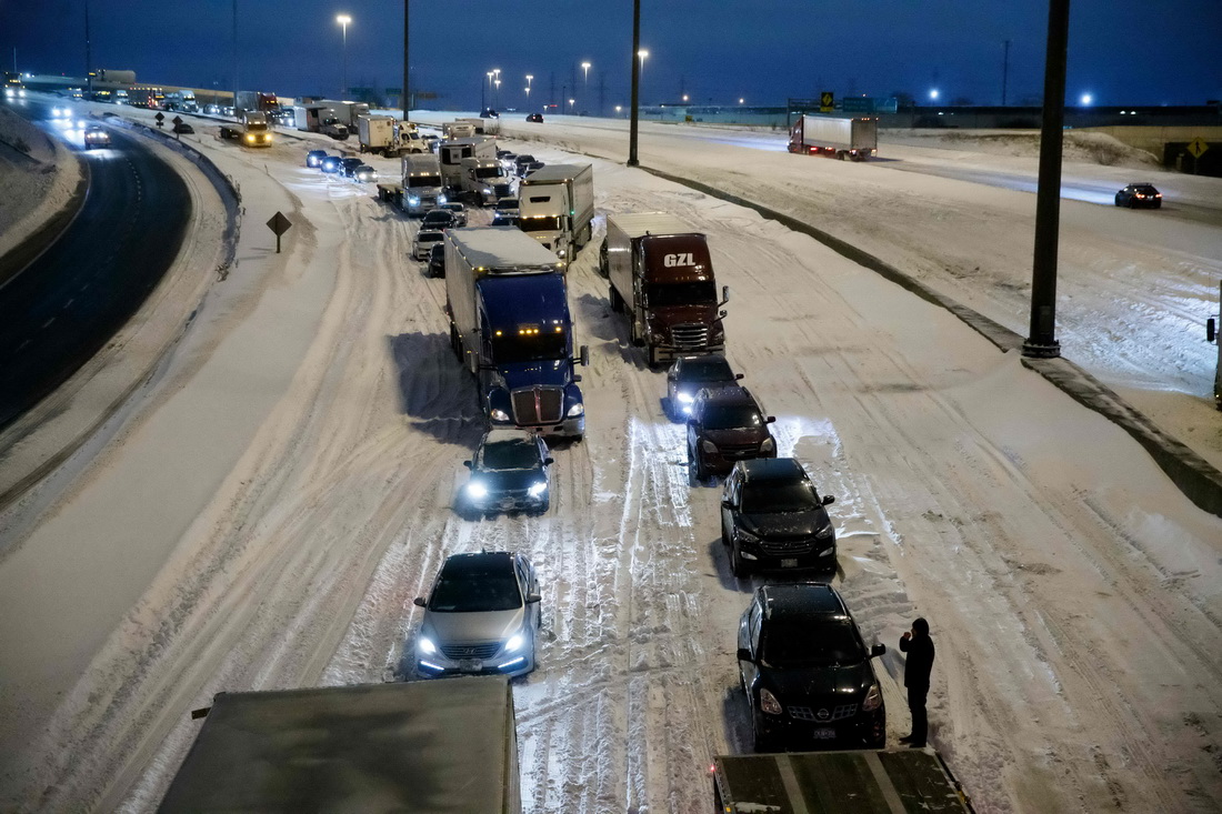1月17日，在加拿大多伦多一处积雪的高速公路上，车辆排起长队。新华社/法新