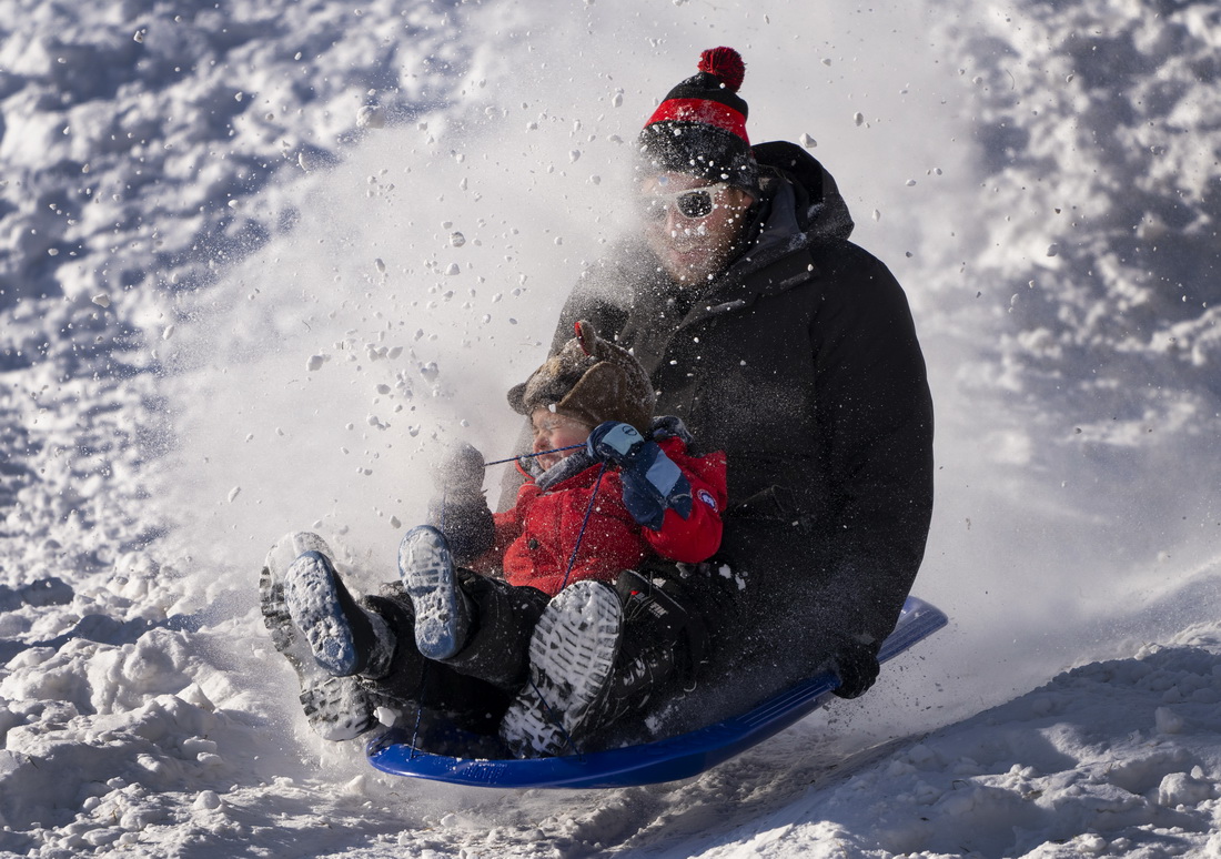 1月18日，人們在加拿大多倫多一處積雪的小坡上玩耍。新華社/美聯