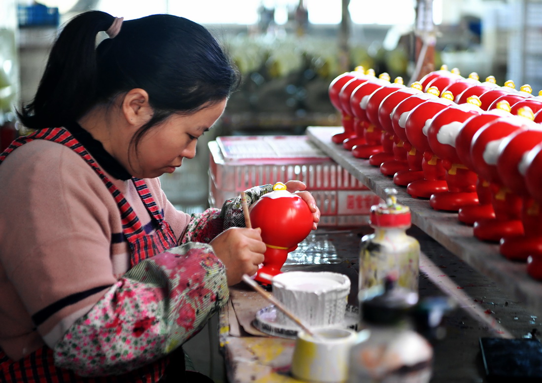 1月19日，在泉州德化縣陶瓷旅游觀光工廠，工人給陶瓷“雪容融”進行上色。