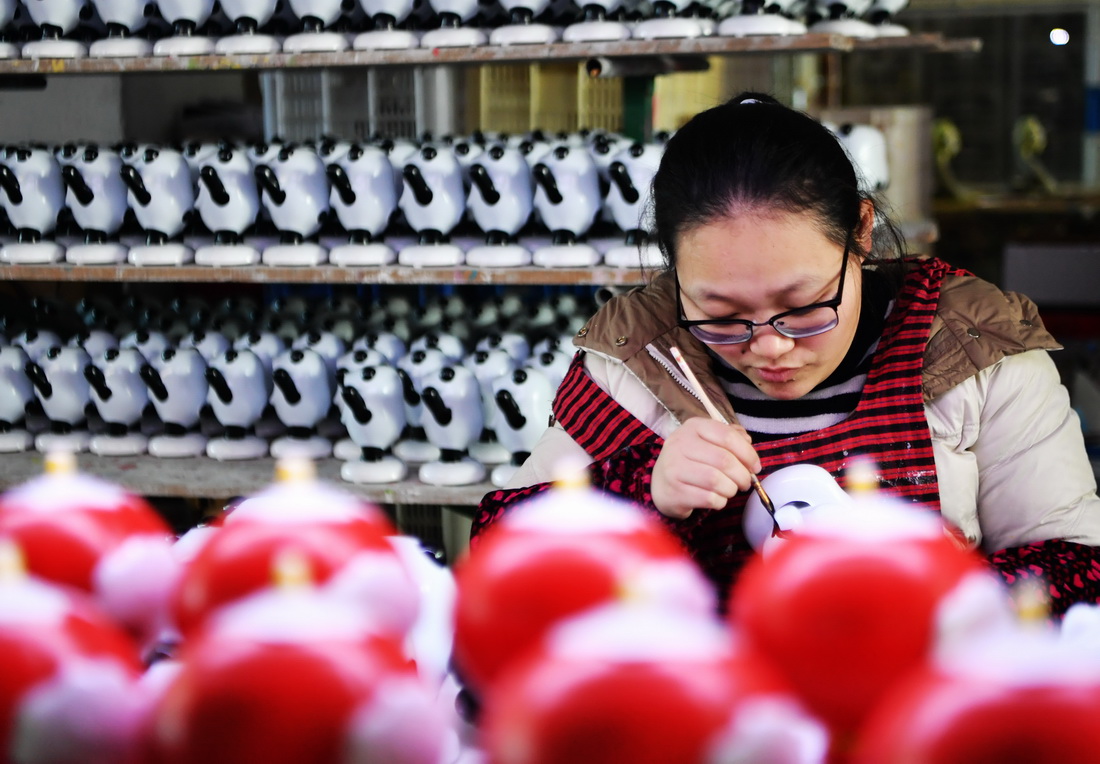 1月19日，在泉州德化縣陶瓷旅游觀光工廠，工人為陶瓷“冰墩墩”、“雪容融”上色。