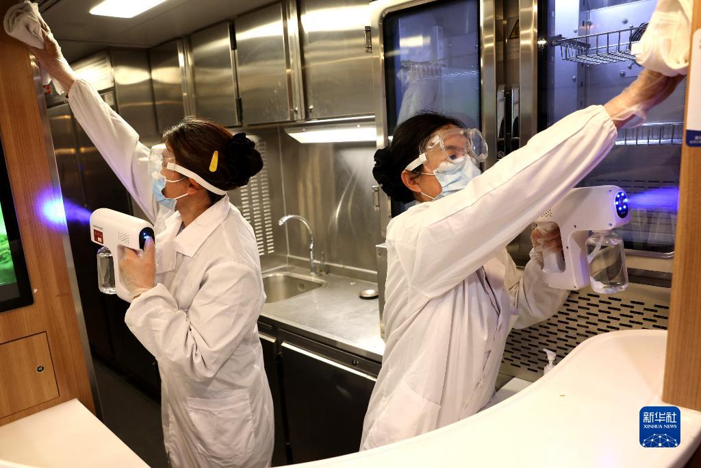 1月21日，工作人员在上海虹桥火车站手持喷雾器对高铁列车进行消毒。