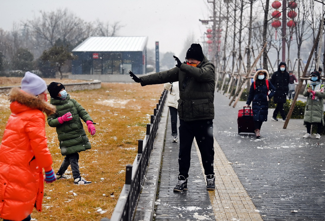 1月23日，小朋友在街头与家人打雪仗。