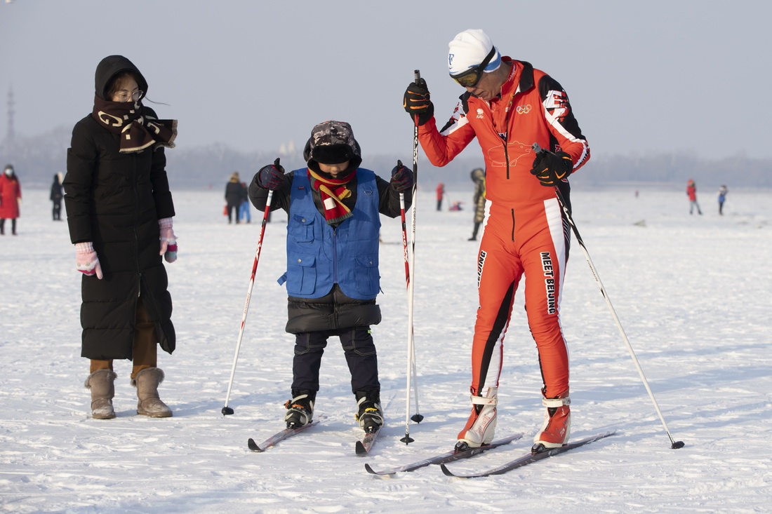 1月23日，滑雪愛好者在冰封的江面上體驗滑雪。