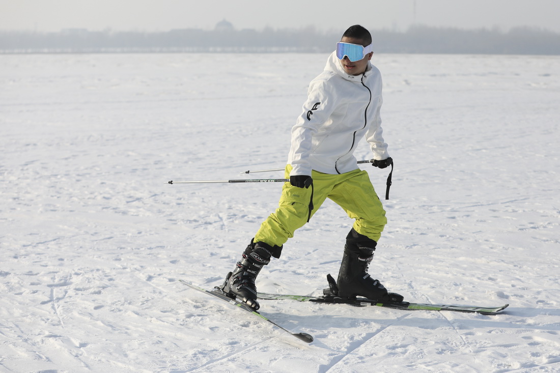 1月23日，一名滑雪愛好者在冰封的江面上體驗滑雪。