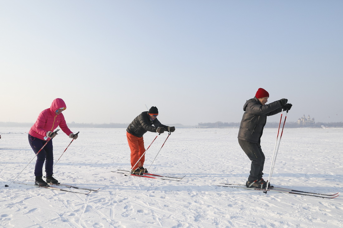 1月23日，滑雪愛好者在冰封的江面上體驗滑雪。