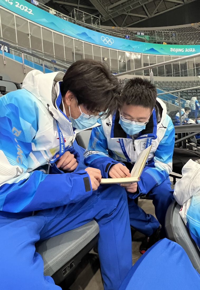在國家體育館，譚夏（右）與同學劉子賀交流冬奧志願服務學習心得（1月24日攝，手機照片）。新華社發