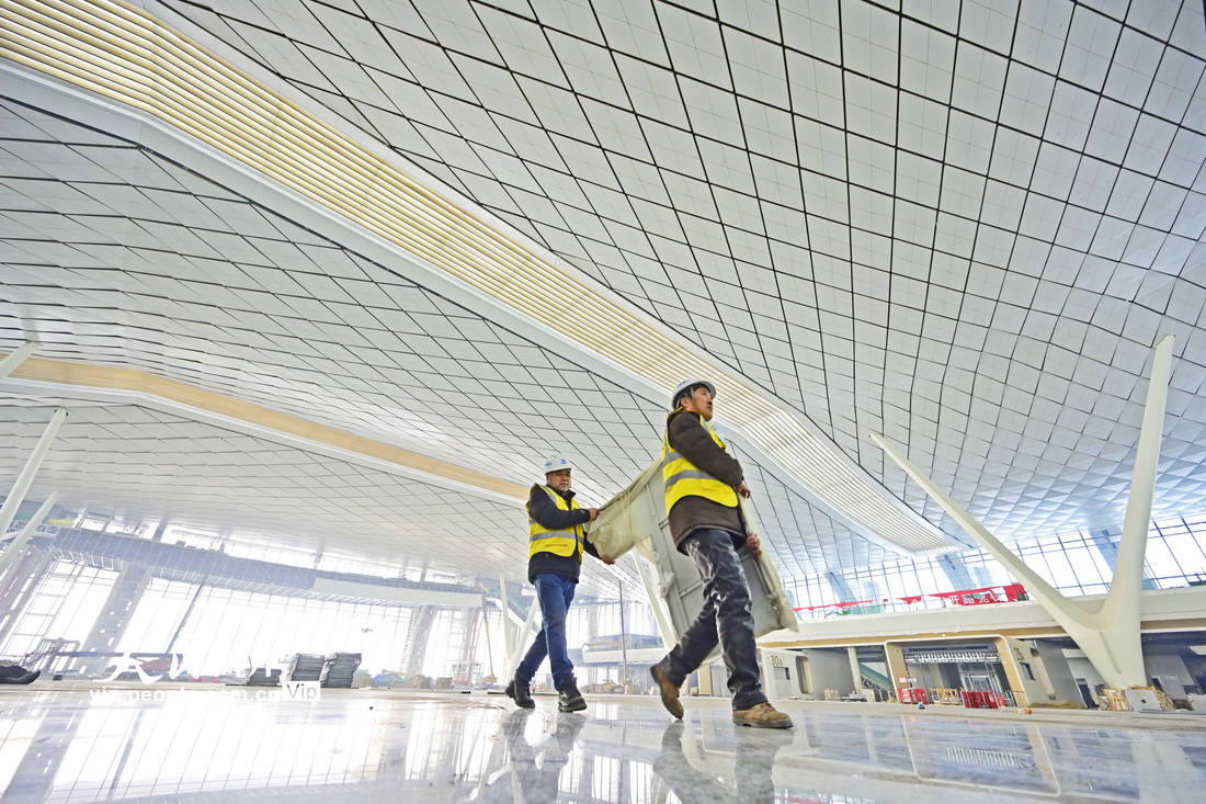 1月25日，中鐵建工的施工人員正在鄭州南站候車大廳搬運裝飾材料。