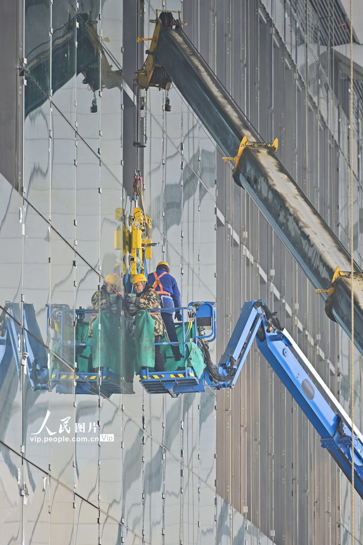 1月25日，中鐵建工的施工人員正在安裝鄭州南站的玻璃幕牆。